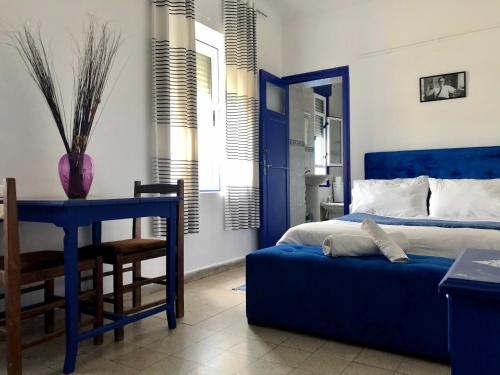 a blue bedroom with a blue bed and a table at El Muniria in Tangier