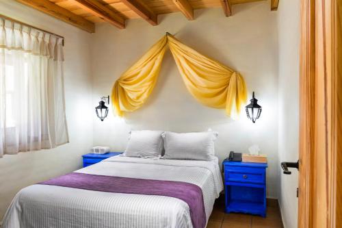 a bedroom with a large bed with yellow curtains at Cabañas Sierra Mazamitla in Mazamitla