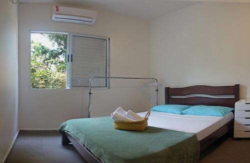 a bedroom with two beds and a window at Pousada Tubes Maresias in Maresias