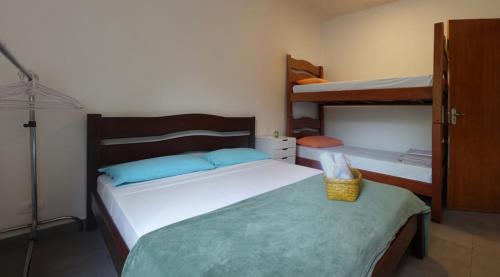 a bedroom with two beds and two bunk beds at Pousada Tubes Maresias in Maresias