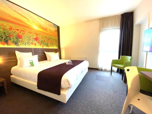 a hotel room with a bed and a painting on the wall at Hotel-Restaurant Horizon Ath-Lessines in Ghislenghien