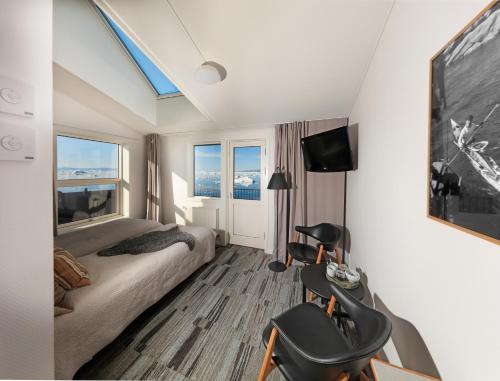 Habitación de hotel con cama y ventana en Hotel Icefiord en Ilulissat