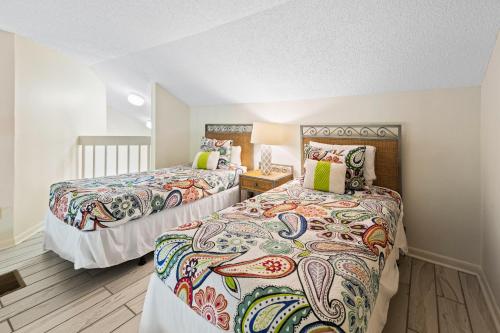 a bedroom with two beds and a table with a lamp at Sunshine Cottage in Destin