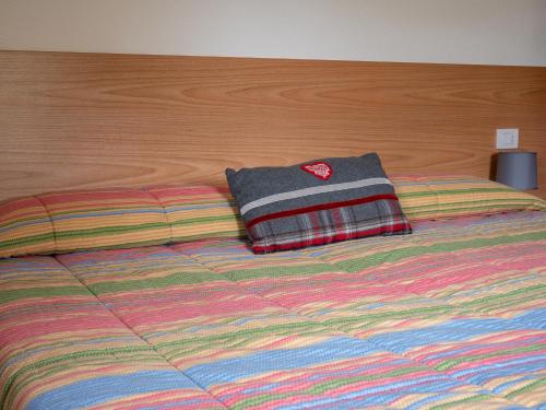 a bed with a colorful blanket and a pillow on it at Bait Nof - Trepalle in Livigno
