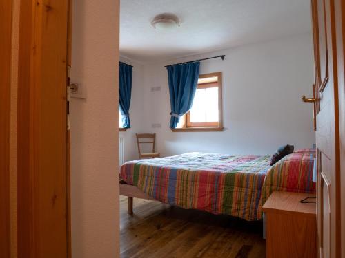 a bedroom with a bed and a window at Bait Nof - Trepalle in Livigno