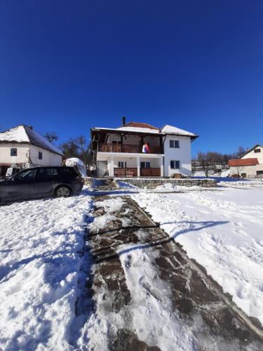 a house with a car parked in the snow at Rujan 1 in Cvetići