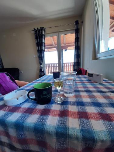 a table with a table cloth with a plate and a glass at Rujan 1 in Cvetići