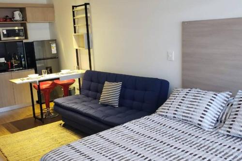 a living room with a blue couch and a kitchen at Monoambiente de Lujo en Equipetrol - You in Santa Cruz de la Sierra