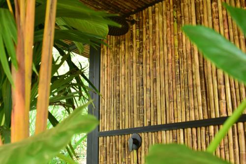 a bamboo building with a window and some plants at Bio Habitat Hotel in Armenia