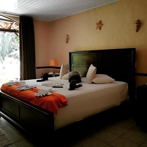 a bedroom with a large bed with stuffed animals on it at Hotel Belvedere Playa Samara Costa Rica in Sámara