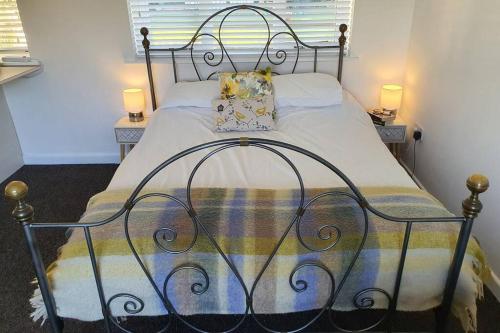 uma cama num quarto com duas lâmpadas nas mesas em The Piggery - Corfe Mullen em Corfe Mullen