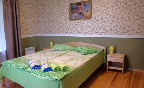 a bedroom with a bed with slippers on it at Leču muiža in Lēči