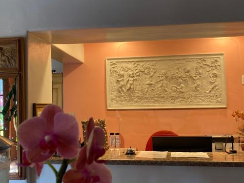 a painting on the wall of a room with pink flowers at Villa Rosa Inn in Santa Barbara