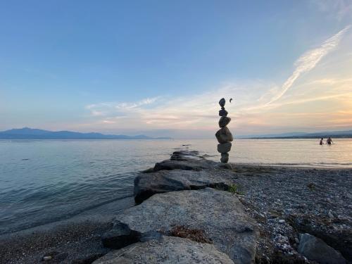 a stack of rocks on the shore of the water at La Chambre #11 in Preverenges
