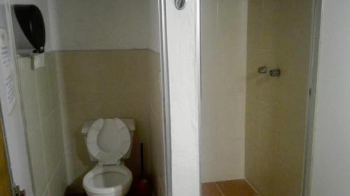 a small bathroom with a toilet and a shower at Rossco Hostel & Hotel in San Cristóbal de Las Casas
