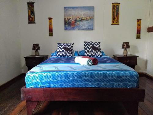 1 dormitorio con 1 cama azul y 2 lámparas en Sunset Chill Out Bed & Breakfast, en Sámara