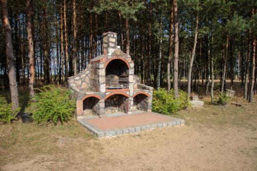 a stone oven sitting in the middle of a field at Pensjonat Zakątek in Lidzbark