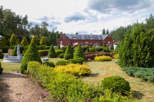 a house with a garden with trees and bushes at Pensjonat Zakątek in Lidzbark