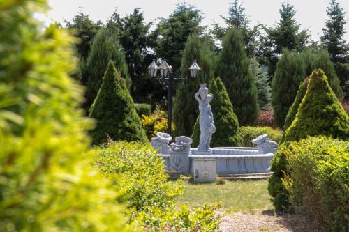 a fountain in the middle of a garden at Pensjonat Zakątek in Lidzbark