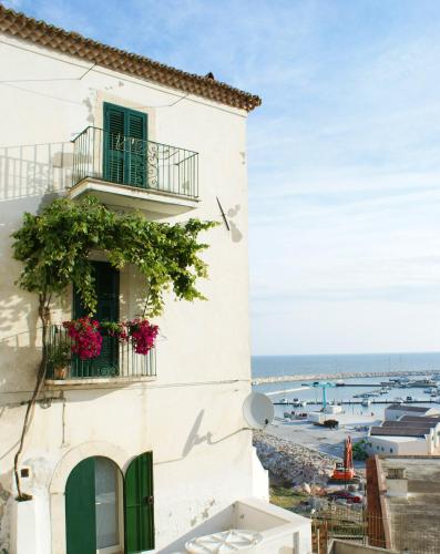 a white building with flowers on a balcony at Park Hotel Villa Americana in Rodi Garganico