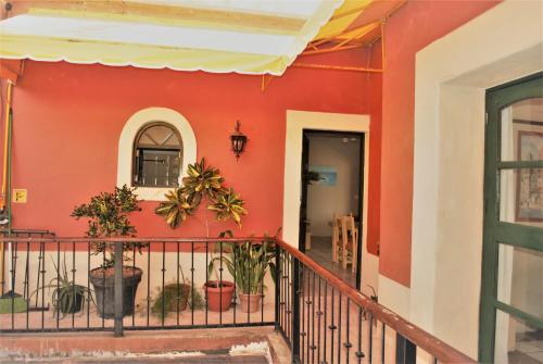 a red house with plants on a balcony at Hotel Belmar in Isla Mujeres