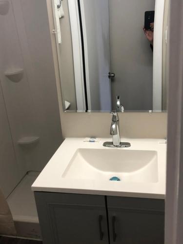 ein Badezimmer mit einem weißen Waschbecken und einem Spiegel in der Unterkunft Trolley Stop Motel, Media ,Near PHL Airport PA in Media