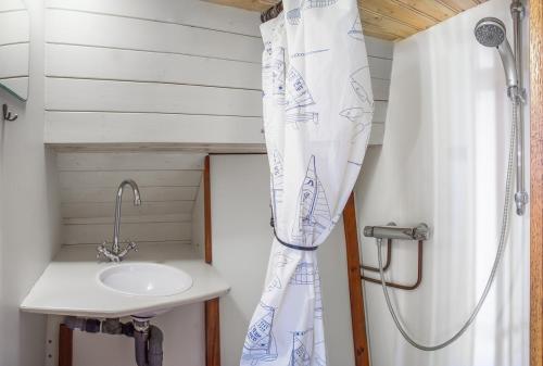 a bathroom with a sink and a shower curtain at De Onderneming in Zwartsluis