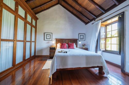 a bedroom with a large bed with red pillows at Hotel Rural Las Calas in Vega de San Mateo
