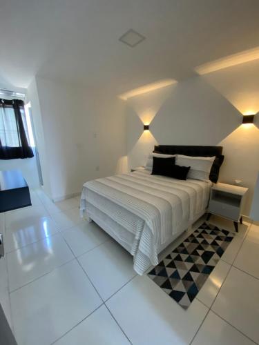 a white bedroom with a bed and a checkered floor at Flat Bugayalê in Garanhuns