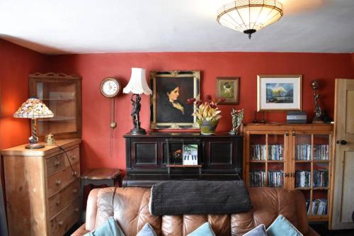 a living room with red walls and a couch at Stunning 18th Century 5 Bed House Old-Town Hastings in Hastings