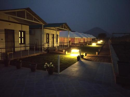 a group of buildings with lights at night at Shivir Aranya - Wilderness Resort in Alwar