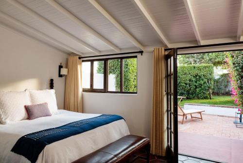 a bedroom with a bed and a sliding glass door at Ingleside Estate Hotel & Bungalows- Adults Only in Palm Springs
