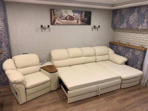 a living room with two white couches and a table at Amber Apartments in Kaliningrad