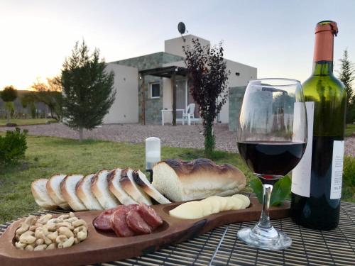 a plate of bread and a bottle of wine and a glass at Cabañas EcoNature in Valle Grande