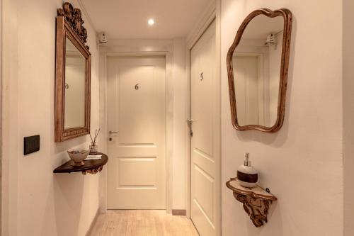 un couloir avec une porte blanche et un miroir dans l'établissement Aiello Rooms, à Milan