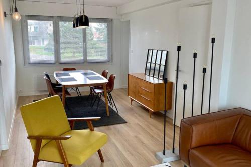 un salon avec une table, des chaises et un canapé dans l'établissement Magnifique Appartement Sainte Cécile Plage, à Camiers