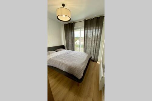 Habitación pequeña con cama y ventana en Magnifique Appartement Sainte Cécile Plage, en Camiers