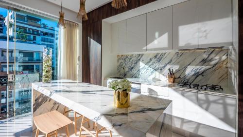 a kitchen with a marble counter with two stools at PIER 57 - 208 Best 2 BR Condo in Romantic Zone in Puerto Vallarta