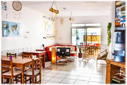 a restaurant with tables and chairs and a couch at ATMA Hostel & Yoga in Huanchaco