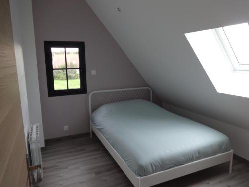 niewielka sypialnia z łóżkiem i oknem w obiekcie au coeur des caps 2 w mieście Audinghen