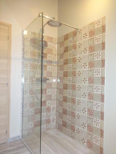 une douche avec une porte vitrée dans une salle de bain dans l'établissement au coeur des caps 2, à Audinghen