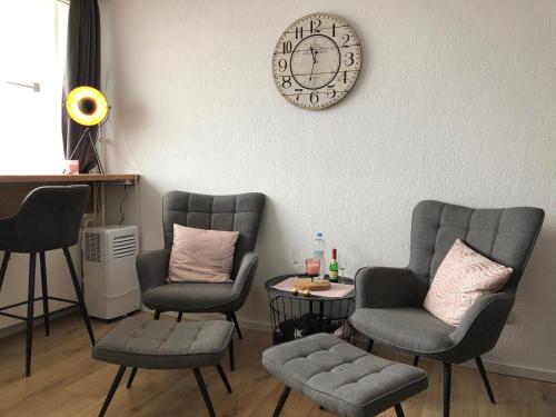 a waiting room with chairs and a clock on the wall at Ferienwohnung Rapunzel in Altenau