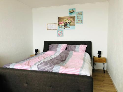 1 cama con sábanas rosas y blancas en un dormitorio en Ferienwohnung Rapunzel, en Altenau