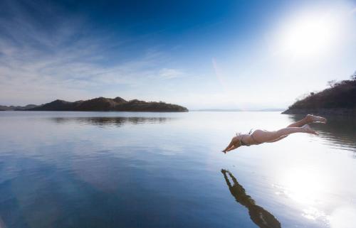 a person swimming in a body of water at Hotel Del Dique in Coronel Moldes