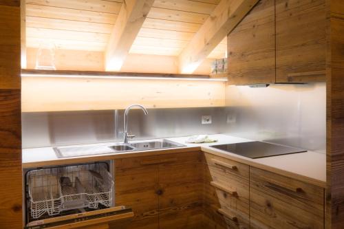 una cocina con armarios de madera y fregadero en Pigala Al Drit, en Rivamonte