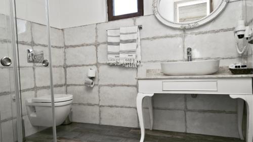 uma casa de banho com um WC, um lavatório e um espelho. em Dedehan Retreat Otel em Muğla