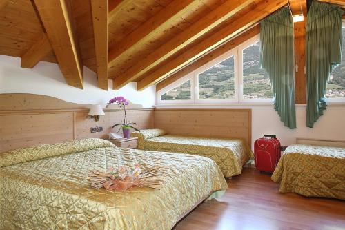 a bedroom with two beds and a red suitcase at Hotel Sant'Ilario in Rovereto