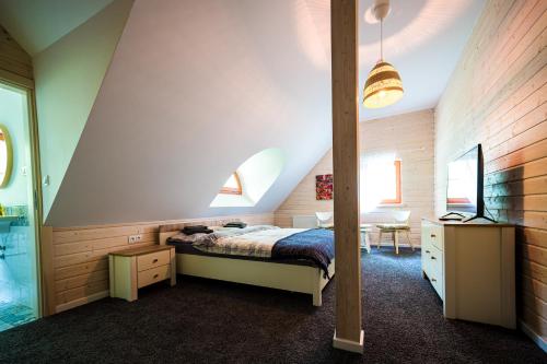 a attic bedroom with a bed and a desk at Brzozowy Gaj in Główczyce