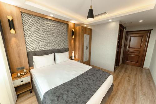 a bedroom with a large white bed and a wooden floor at World Heritage Center Hotel in Istanbul
