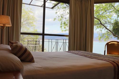 a bedroom with a bed and a large window at Hotel Del Dique in Coronel Moldes